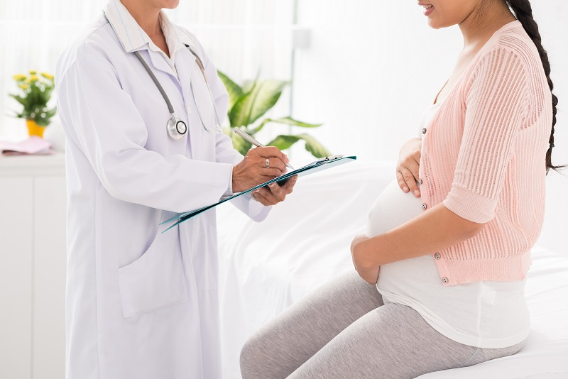 Imagem ilustrativa de médico orientando paciente mulher grávida.
